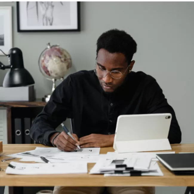 Man filling out paperwork at desk
